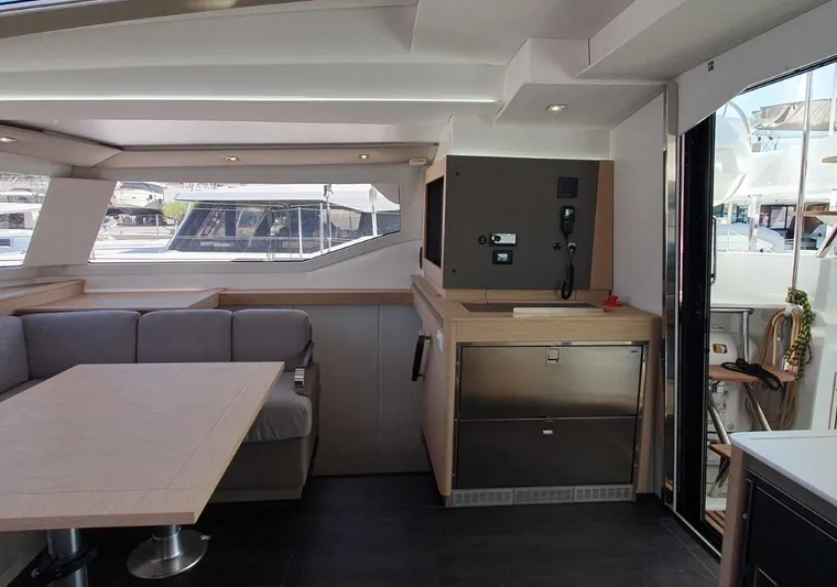  Yacht Photos Pics Luxurious interior of 2024 Fountaine Pajot Catamaran Elba 45 with modern seating and kitchen area.
