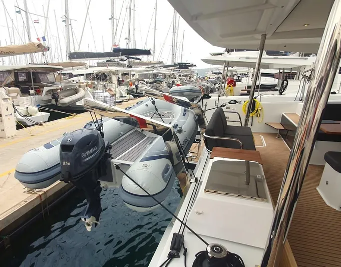  Yacht Photos Pics 2024 Fountaine Pajot Catamaran Elba 45 docked, featuring inflatable dinghy and Yamaha outboard motor.