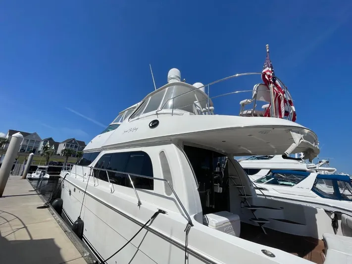 Seas The Day Yacht Photos Pics 2006 Carver 56 Voyager yacht docked, featuring sleek design and American flag.
