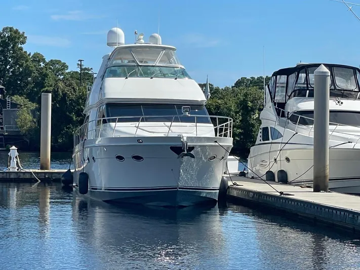 Seas The Day Yacht Photos Pics 2006 Carver 56 Voyager yacht docked at marina, surrounded by calm water and trees.