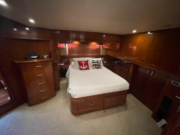 Seas The Day Yacht Photos Pics Luxurious bedroom interior of 2006 Carver 56 Voyager yacht with wood paneling and cozy bedding.