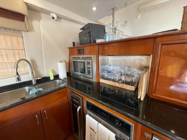 Seas The Day Yacht Photos Pics Kitchen area of a 2006 Carver 56 Voyager yacht with modern appliances and wooden cabinetry.