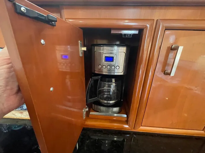 Seas The Day Yacht Photos Pics Coffee maker inside a wooden cabinet on a 2006 Carver 56 Voyager yacht.