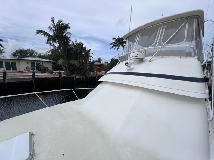 " A La Mer " Yacht Photos Pics 1988 Bertram 43 Convertible yacht docked near waterfront homes.