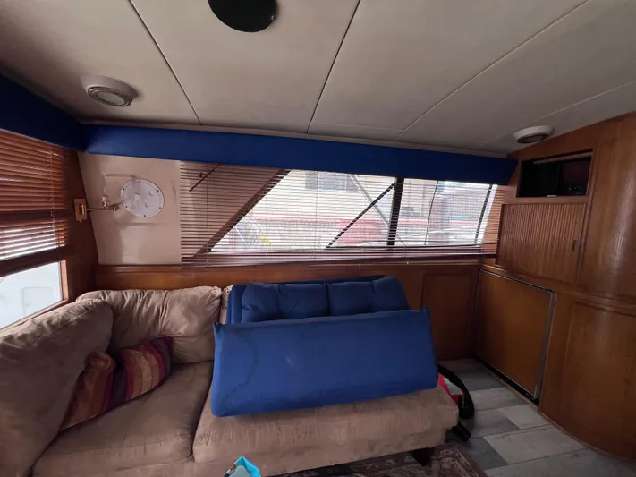 " A La Mer " Yacht Photos Pics Interior of 1988 Bertram 43 Convertible yacht with beige sofa and wooden cabinetry.