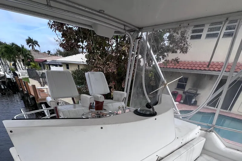 " A La Mer " Yacht Photos Pics 1988 Bertram 43 Convertible boat cockpit with white seating and steering wheel.