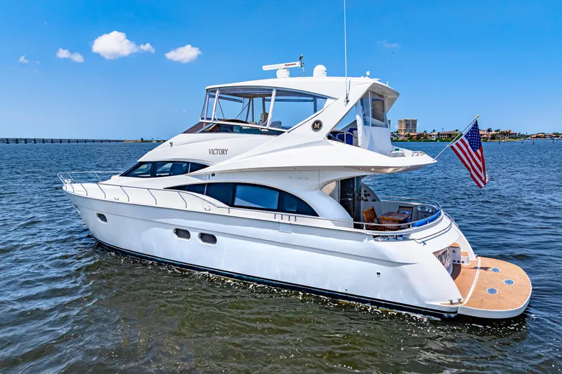Victory Yacht Photos Pics Luxury 2005 Marquis 59 yacht cruising on open water with American flag.
