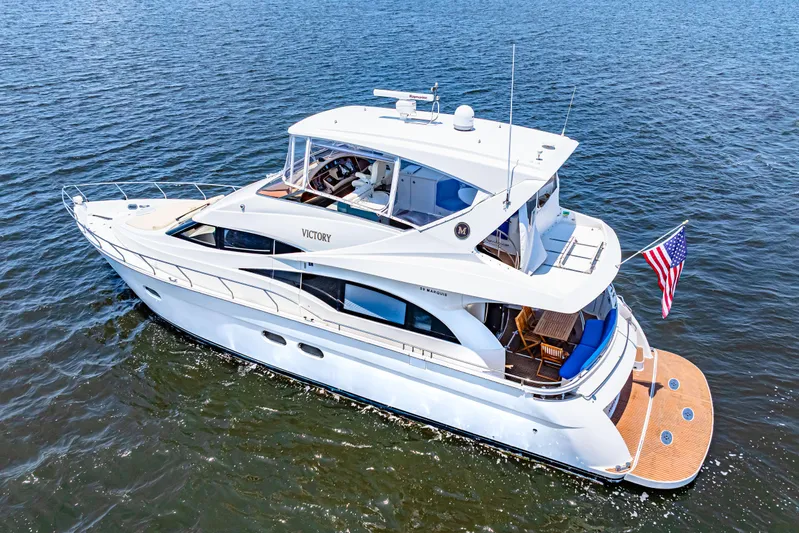 Victory Yacht Photos Pics 2005 Marquis 59 yacht cruising on open water with American flag displayed.