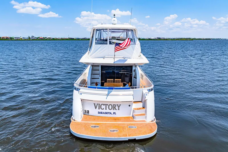Victory Yacht Photos Pics 2005 Marquis 59 yacht named "Victory" on open water, rear view with American flag.