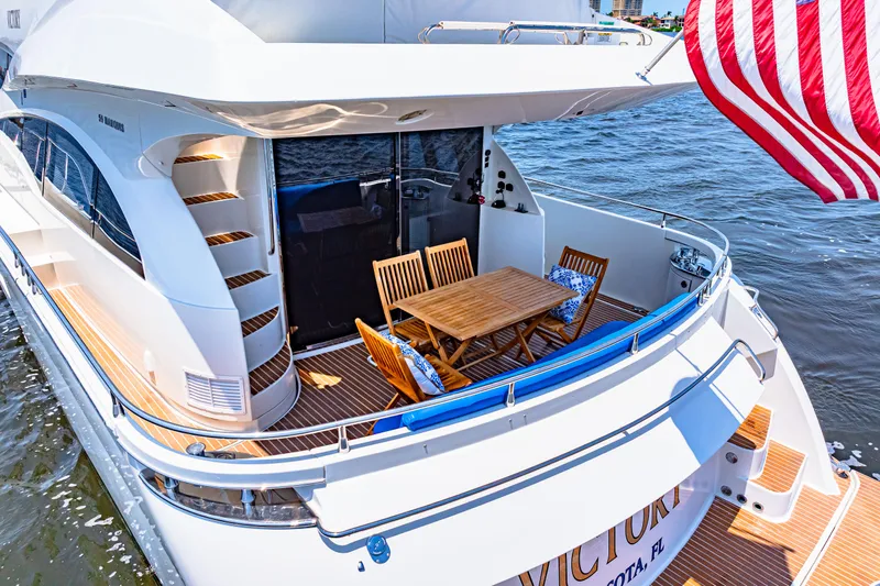 Victory Yacht Photos Pics Luxury 2005 Marquis 59 yacht with outdoor dining area and American flag.