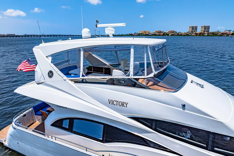 Victory Yacht Photos Pics Luxurious 2005 Marquis 59 yacht named "Victory" cruising on a serene blue waterway.