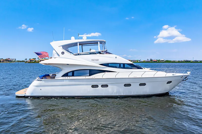 Victory Yacht Photos Pics Luxury 2005 Marquis 59 yacht cruising on a sunny day with clear blue skies.