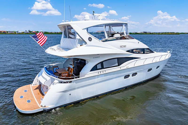 Victory Yacht Photos Pics Luxury 2005 Marquis 59 yacht cruising on open water with American flag.