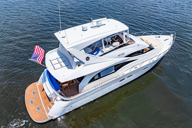 Victory Yacht Photos Pics Luxury 2005 Marquis 59 yacht cruising on open water with American flag.
