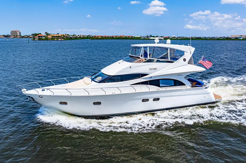 Victory Yacht Photos Pics 2005 Marquis 59 yacht cruising on a sunny day with American flag.