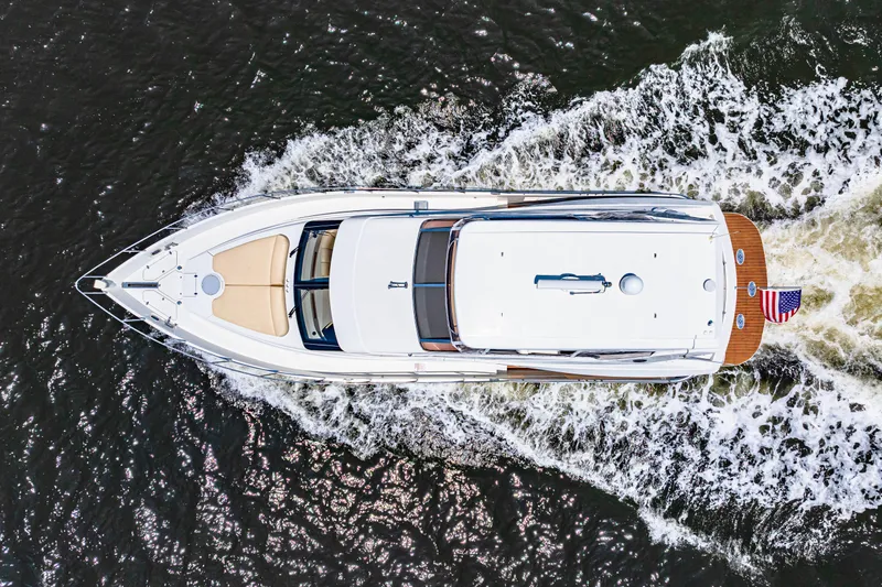 Victory Yacht Photos Pics Aerial view of 2005 Marquis 59 yacht cruising on water with American flag.