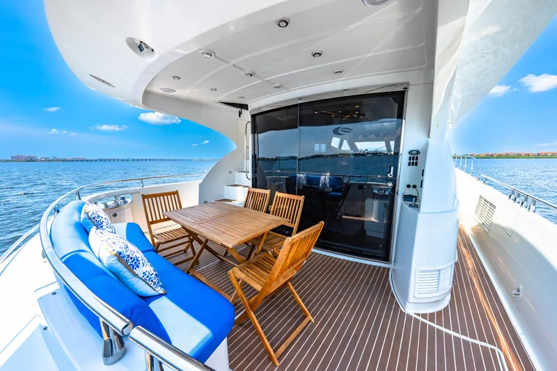 Victory Yacht Photos Pics Luxurious 2005 Marquis 59 yacht deck with seating, table, and ocean view.