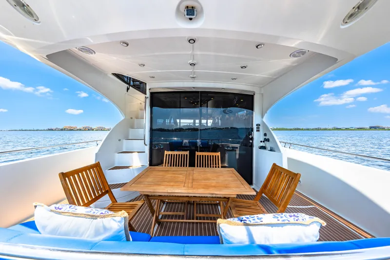 Victory Yacht Photos Pics Luxurious 2005 Marquis 59 yacht deck with wooden furniture, overlooking serene waters.