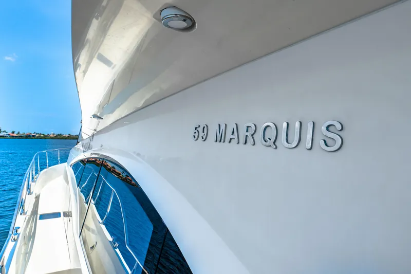 Victory Yacht Photos Pics 2005 Marquis 59 yacht side view with nameplate, against a clear blue sky and water.
