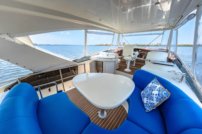 Victory Yacht Photos Pics Luxurious 2005 Marquis 59 yacht interior with blue seating, table, and scenic ocean view.