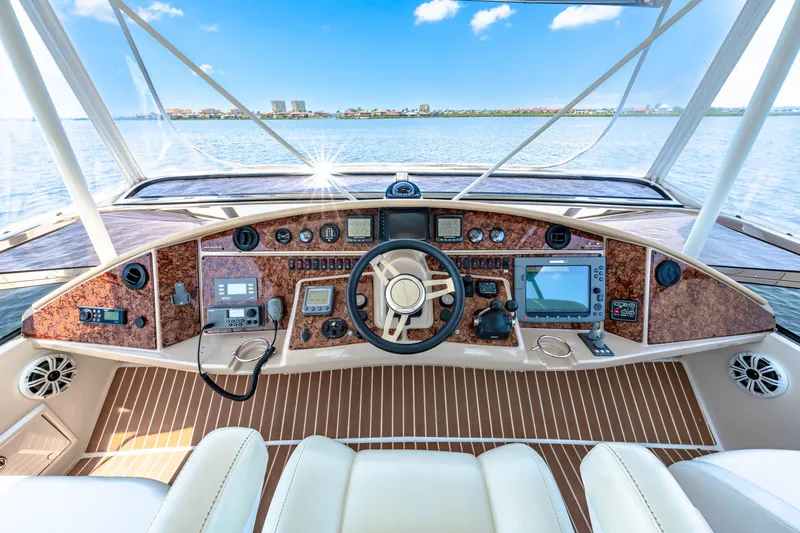 Victory Yacht Photos Pics Helm of 2005 Marquis 59 yacht with advanced navigation equipment and scenic water view.