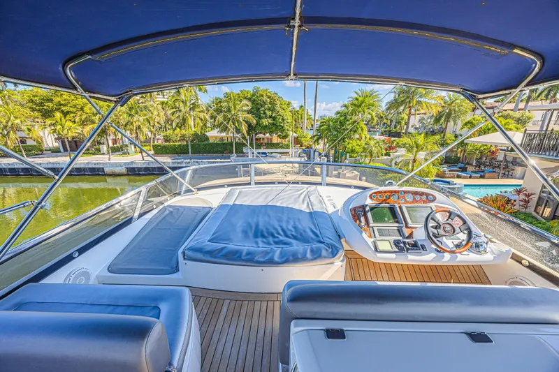 Big Chubby Xl Yacht Photos Pics Luxurious 2006 Sunseeker 75 Yacht with spacious deck and modern helm, docked by tropical scenery.