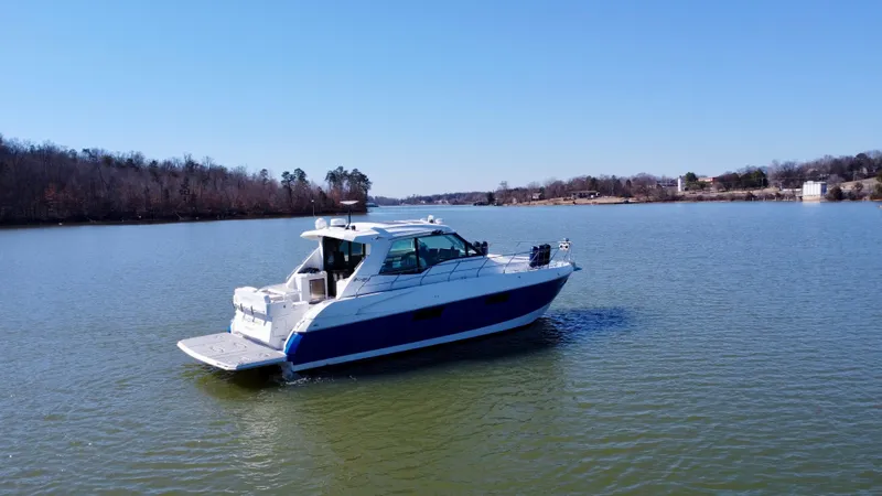 Radical Physics Yacht Photos Pics 2012 Cruisers Yachts 48 Cantius on a serene lake under clear blue skies.