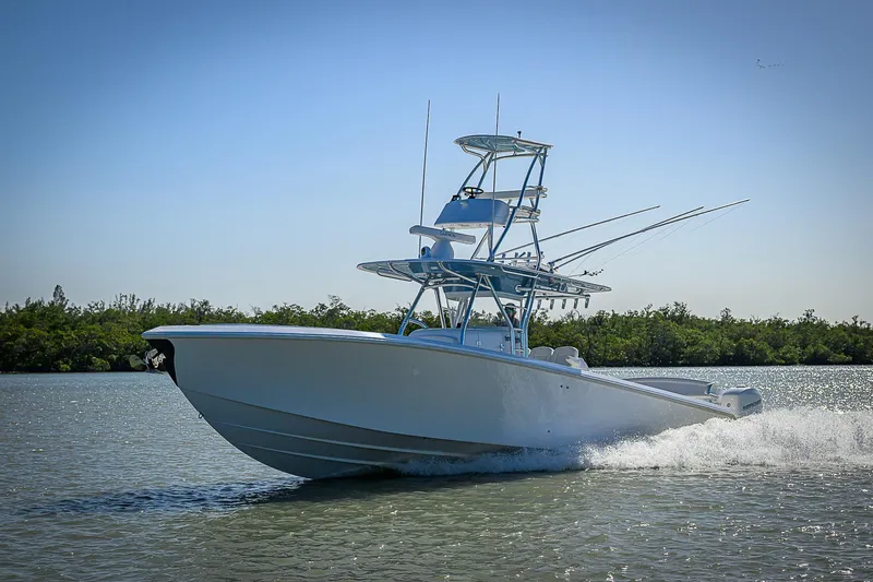 Mare Yacht Photos Pics 2019 Bahama 41 boat cruising on water with lush greenery in the background.