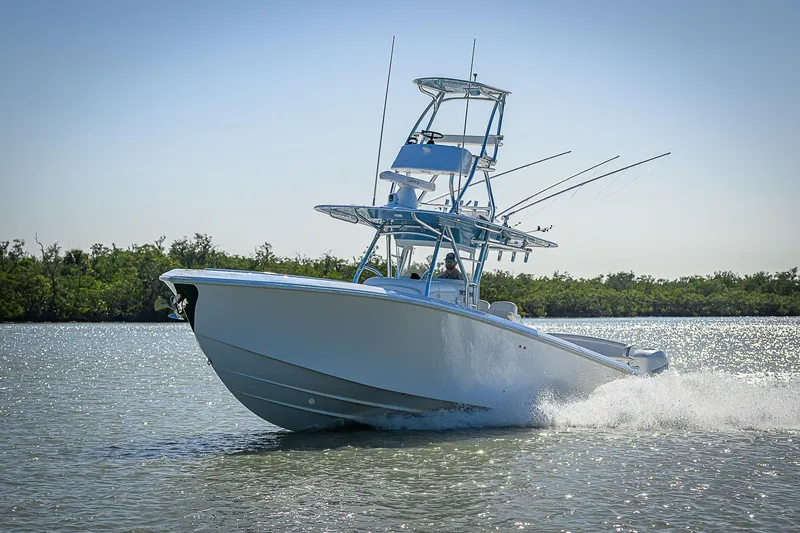 Mare Yacht Photos Pics 2019 Bahama 41 boat cruising on water, surrounded by lush greenery.