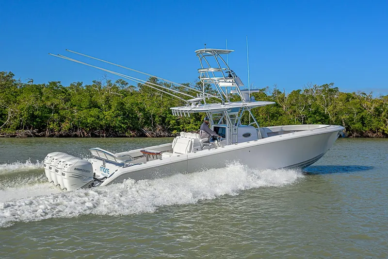 Mare Yacht Photos Pics 2019 Bahama 41 boat cruising on a sunny day with lush greenery in the background.