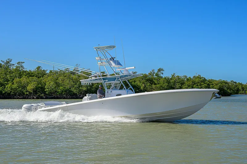 Mare Yacht Photos Pics 2019 Bahama 41 boat cruising on a sunny day near lush green shoreline.