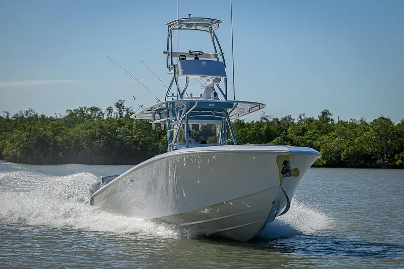 Mare Yacht Photos Pics 2019 Bahama 41 boat cruising on water, surrounded by lush greenery.