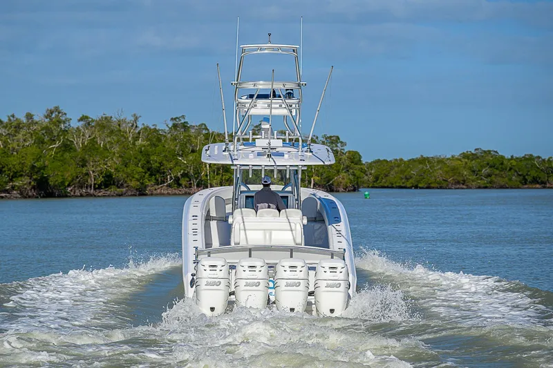 Mare Yacht Photos Pics 2019 Bahama 41 boat cruising on a calm waterway with lush greenery.