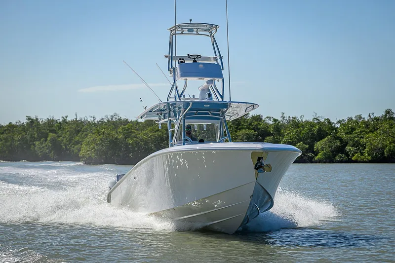 Mare Yacht Photos Pics 2019 Bahama 41 boat cruising on water with lush greenery in the background.