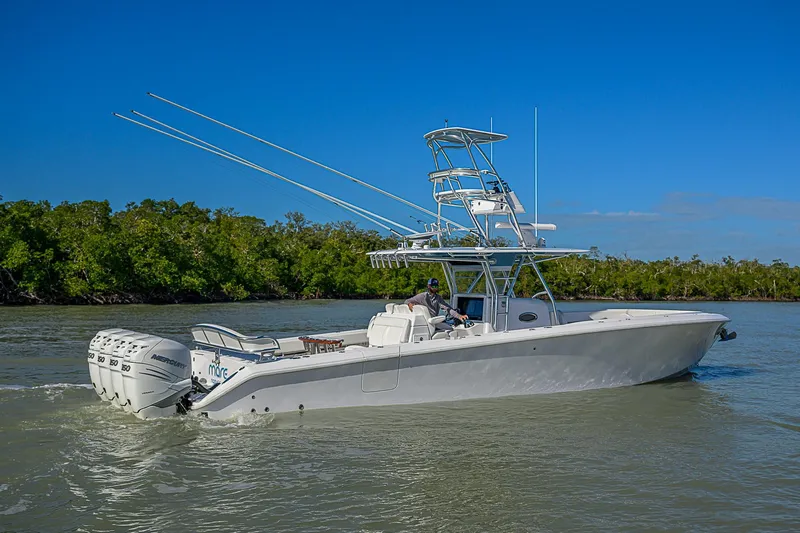 Mare Yacht Photos Pics 2019 Bahama 41 boat cruising on a sunny day with lush greenery in the background.