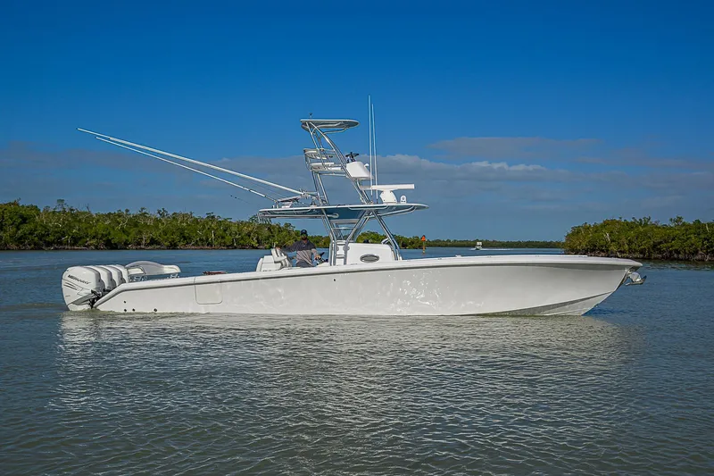 Mare Yacht Photos Pics 2019 Bahama 41 boat on calm water, clear sky, lush greenery in background.