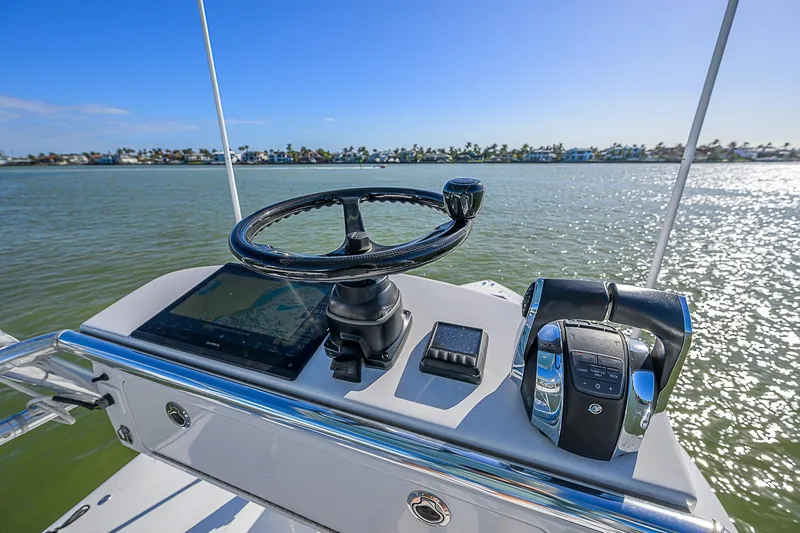 Mare Yacht Photos Pics Helm of 2019 Bahama 41 boat with steering wheel and controls, overlooking calm waters.