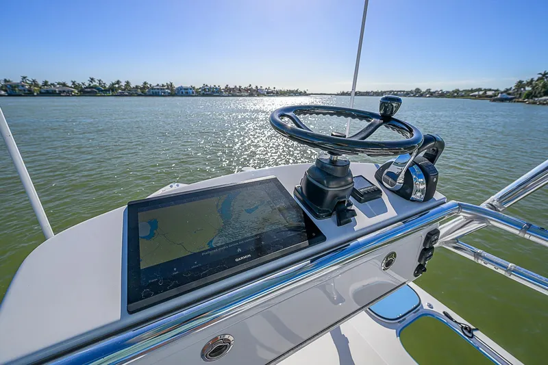 Mare Yacht Photos Pics Helm of 2019 Bahama 41 boat with navigation screen and steering wheel on calm water.
