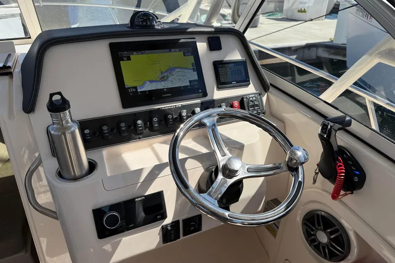  Yacht Photos Pics 2023 Grady-White Adventure 218 helm with steering wheel, navigation display, and controls.