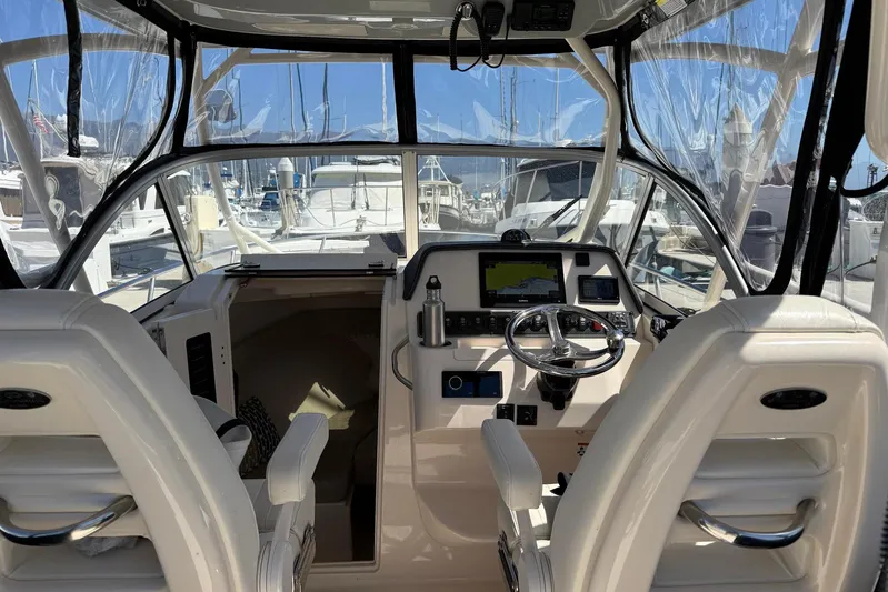  Yacht Photos Pics 2023 Grady-White Adventure 218 boat cockpit with steering wheel and navigation equipment.