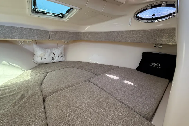  Yacht Photos Pics 2023 Grady-White Adventure 218 cabin interior with cozy bedding and natural light.