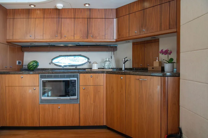 Yoda Yacht Photos Pics Luxurious kitchen interior of 2008 Sunseeker Predator 62 yacht with wood cabinetry and modern appliances.