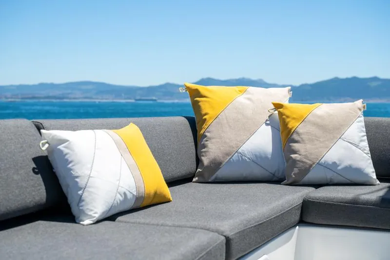  Yacht Photos Pics Gray seating with colorful cushions on a 2024 Lagoon 43 yacht, overlooking a serene ocean view.