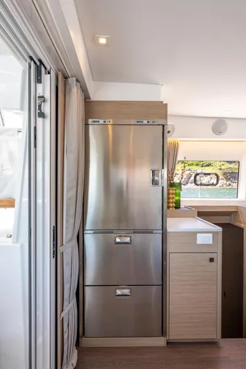  Yacht Photos Pics 2024 Lagoon 43 yacht interior with modern stainless steel appliances and sleek wooden cabinetry.