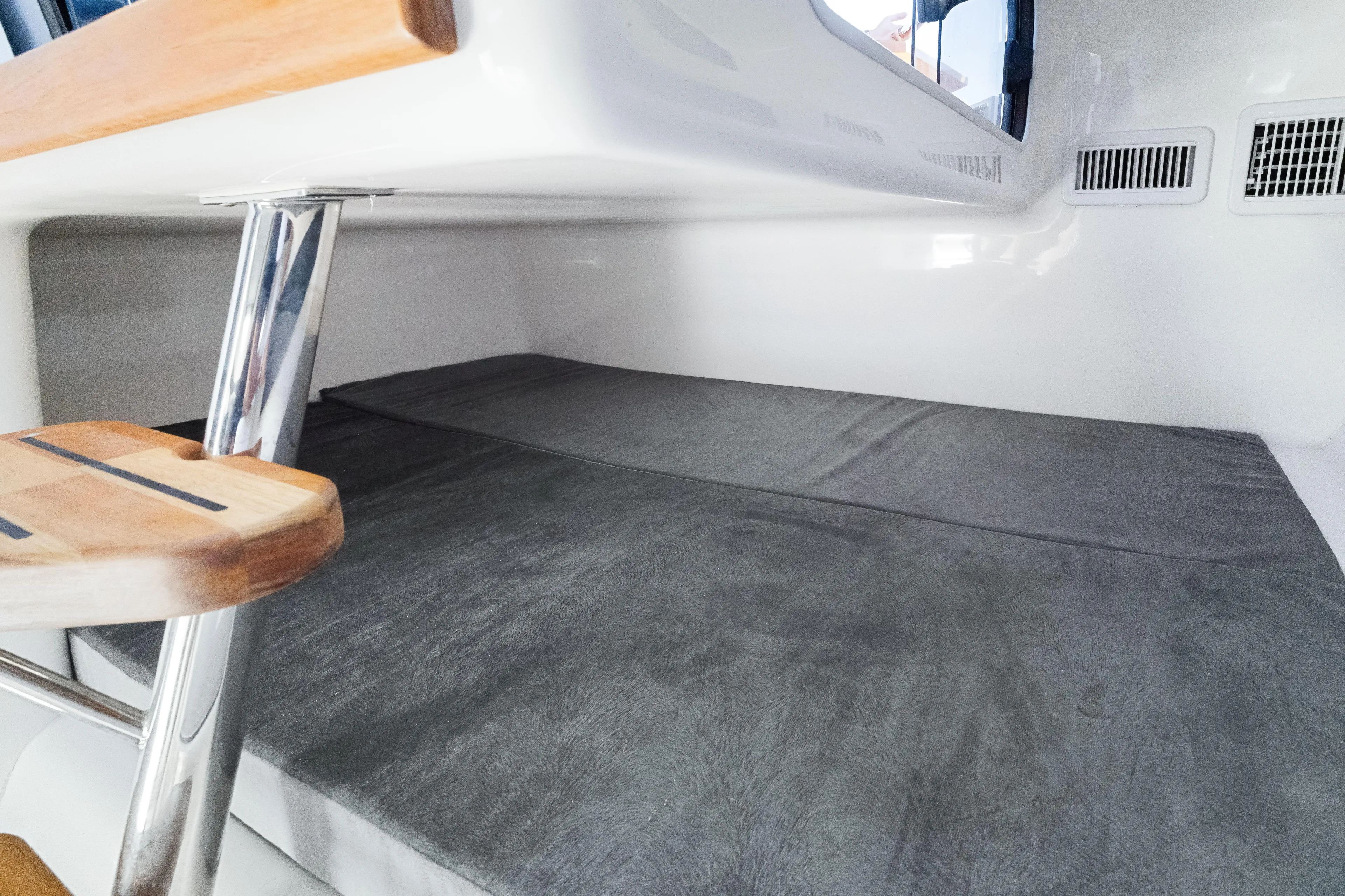  Yacht Photos Pics Interior of 2025 Hanover 305 boat with gray cushioned seating and wooden accents.