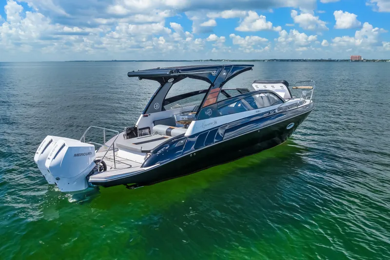  Yacht Photos Pics 2025 Hanover 305 boat on calm water under a blue sky.