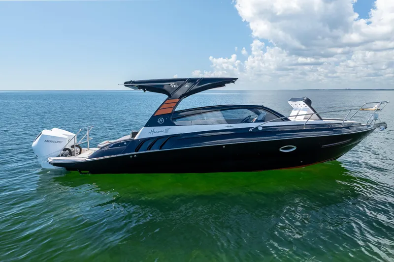  Yacht Photos Pics 2025 Hanover 305 boat on calm water under a partly cloudy sky.