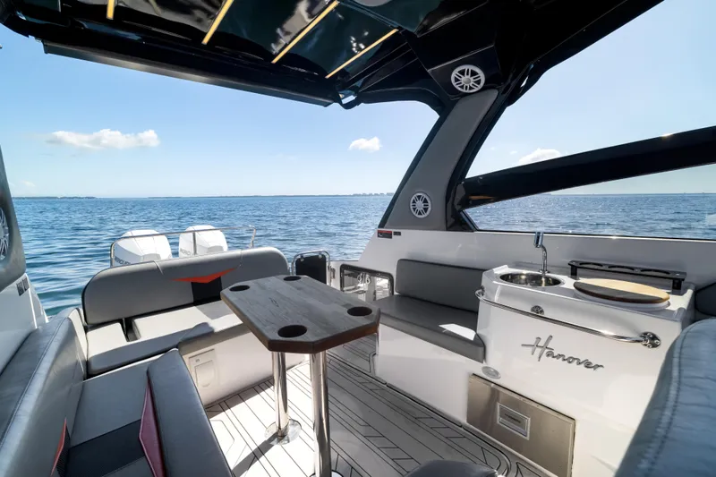  Yacht Photos Pics Luxurious 2025 Hanover 305 boat interior with seating, table, and ocean view.