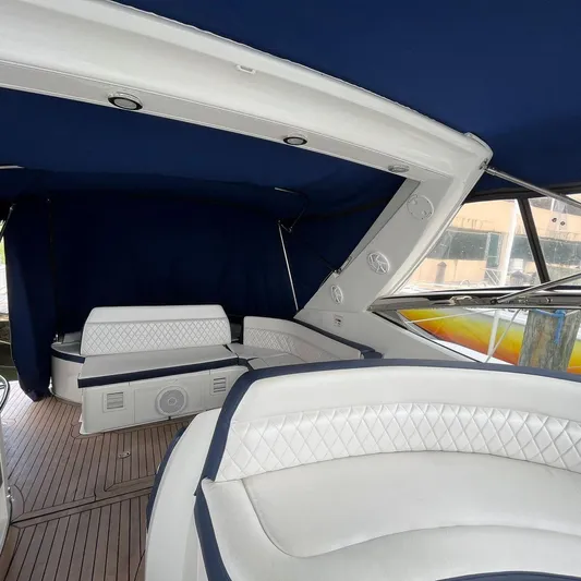  Yacht Photos Pics 2003 Sunseeker Portofino 46 yacht interior with white seating and blue canopy.
