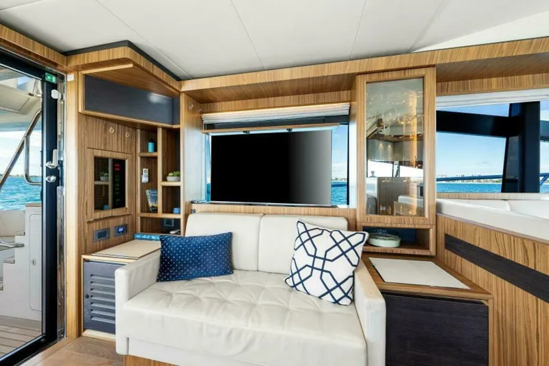 Mama's House Yacht Photos Pics Luxurious interior of 2018 Absolute 60 Flybridge yacht with elegant wood finish and plush seating.
